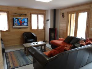 a living room with a couch and a tv at Les Petites Marmottes in Vaujany