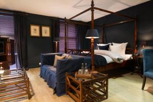Bliss Boutique Hotel في بريدا: غرفة معيشة مع سرير وأريكة زرقاء