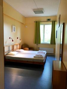 a bedroom with a large bed and a window at Godby Vandrarhem in Godby