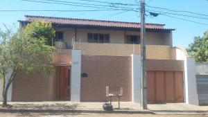 a brick house with a garage and a tree at suítes economy uberlandia in Uberlândia