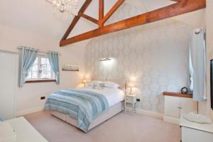 a bedroom with a white bed and a wooden ceiling at Holtby Grange Cottages in York