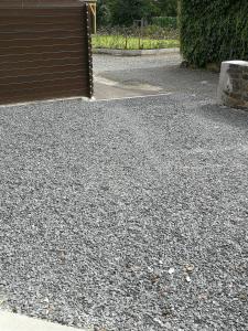 a parking lot with a gate and a bunch of gravel at La clé des vacances in Stavelot