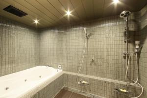 a bathroom with a bath tub and a shower at Small Luxury Ryugin in Kyoto