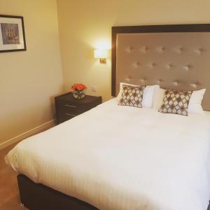 een slaapkamer met een groot wit bed met een hoofdeinde bij Cohannon Inn in Dungannon