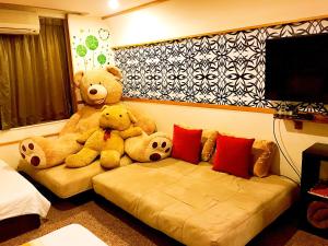 台南的住宿－Hello B&B，两个大泰迪熊坐在一个房间里沙发上