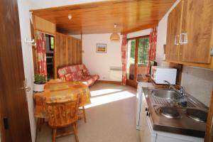 uma cozinha e sala de estar com uma mesa e um sofá em Chalet les arolles em Les Orres