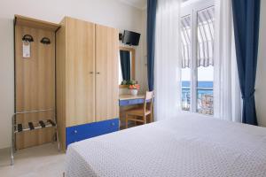 a bedroom with a bed and a view of the ocean at Albergo Teresa in Laigueglia