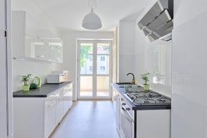 a white kitchen with a stove top oven at MoMi Apartament Blonia Szczecin Herbowa in Szczecin
