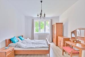 シュチェチンにあるMoMi Apartament Blonia Szczecin Herbowaのベッドルーム1室(ベッド1台、デスク、窓付)
