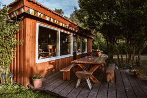 a small cabin with a picnic table and a window at Sunny Nights Homestead Rustic House in Gataučiai +19 photos