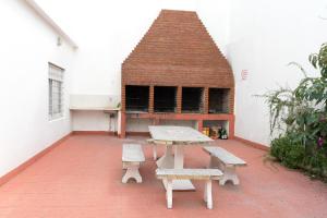 een patio met een picknicktafel en banken in een gebouw bij Departamentos VILLAHERMOSA de Un Dormitorio - Dos Dormitorios y Monoambientes in San Clemente del Tuyú