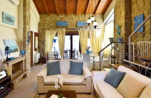 ein Wohnzimmer mit weißen Sofas und blauen Kissen in der Unterkunft Beautiful Sani Villa in Sani Beach