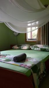 a bed with a comforter on it with a window at De Plantage in Tamanredjo