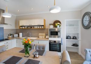 una cocina con una mesa con un jarrón de flores en Shore View Cottage, en Inverness