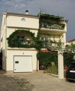 a white building with a white garage at Nera Apartment in Brodarica