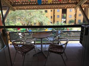 einen Tisch und Stühle auf einem Balkon mit Blick auf ein Gebäude in der Unterkunft Winterville Gravata in Gravatá