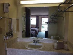 a bathroom with a sink and a large mirror at Western Motel - Camilla in Camilla