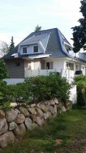 a house with a metal roof on top of a stone wall at Ferienwohnung am Meer in Scharbeutz