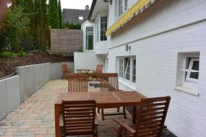 a patio with a wooden table and chairs at Ferienwohnung am Meer mit Wallbox in Scharbeutz
