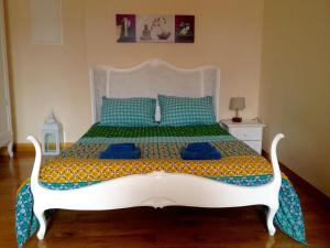 a bedroom with a white bed with blue pillows at Un Joli Pied a Terre in Montignac