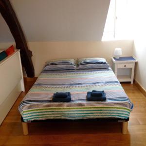 a bed with two bags sitting on top of it at Le Studio in Montignac