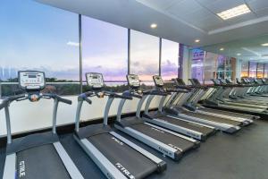 a row of treadmills in a gym with windows at GR Caribe Deluxe All Inclusive in Cancún