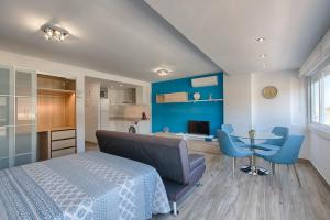 Schlafzimmer mit einem Bett und einem Tisch mit blauen Stühlen in der Unterkunft Estepona Real Classic Apartamento in Estepona