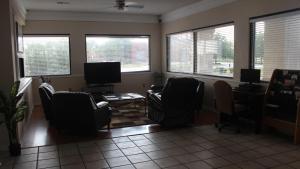 a living room with chairs and a table and windows at Deerfield Inn & Suites in Madison