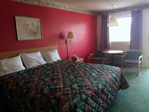 a hotel room with a bed and a red wall at Western Motel - Camilla in Camilla