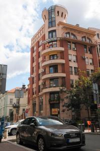 un coche aparcado delante de un edificio alto en Apartment D-22, en Belgrado