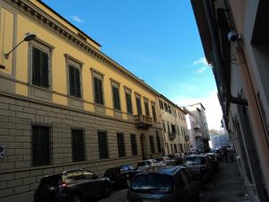 eine Straße mit Autos, die an der Seite eines Gebäudes geparkt sind in der Unterkunft Appartamento Cittadella 39 in Florenz