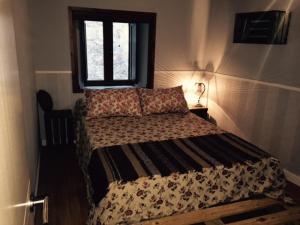 - un lit dans une chambre avec fenêtre dans l'établissement Torremochada, à Cáceres