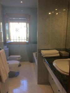 グラナダにあるBonita casa en Barrio de Monachilのバスルーム(洗面台、トイレ付)、窓が備わります。