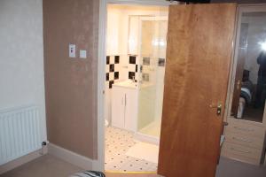 a bathroom with a shower and a glass door at Harbour House Bed & Breakfast - Wick in Wick