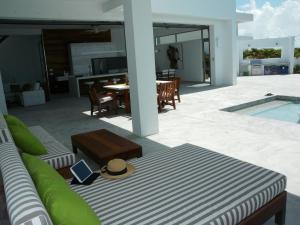 un patio con sofá, mesa y piscina en White Villas Resort - 2-bedroom private villa - V6, en Grace Bay