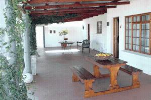un patio al aire libre con mesa y banco en Kronenhoff Guesthouse en Kirkwood
