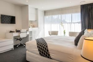 a hotel room with a large bed and a large window at Regent of Rotorua Boutique Hotel in Rotorua