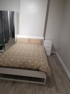 1 dormitorio blanco con 1 cama y suelo de madera en Court Road House en Cardiff