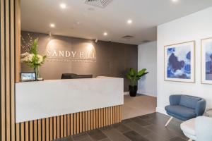 a lobby with a reception desk and a blue chair at Caroline Serviced Apartments Sandringham in Sandringham