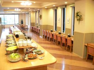 a long table with food on it in a cafeteria at Hotel Route-Inn Aomori Ekimae in Aomori
