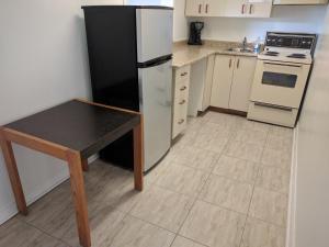 a kitchen with a refrigerator and a table in it at Franklin Motel, Tent & Trailer Park in North Bay