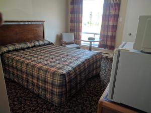 a hotel room with a bed and a window at Franklin Motel, Tent & Trailer Park in North Bay