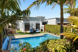 a swimming pool in the backyard of a house with palm trees at Tuscan Retreat Bed & Breakfast - Adults Only in Papamoa