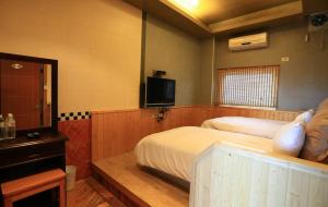 萬里的住宿－萬里仙境溫泉會館 ，酒店客房设有两张床和电视。