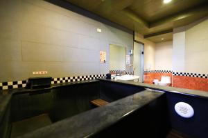 萬里的住宿－萬里仙境溫泉會館 ，一间带水槽和镜子的大浴室