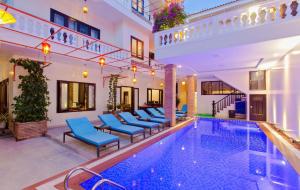 a villa with a swimming pool and blue chairs at Pham Gia Boutique Villa in Hoi An +41 photos