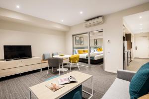 a living room filled with furniture and a tv at Quest Eight Mile Plains in Brisbane