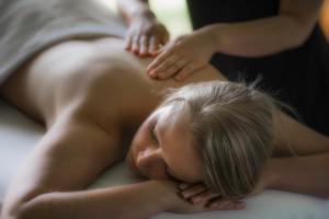 Una mujer acostada en una cama con la cabeza en las manos en Blanket Bay en Glenorchy