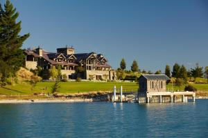 a large house on the shore of a body of water at Blanket Bay in Glenorchy