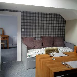 Zimmer mit einem Bett mit einem Tisch und einem Tisch mit einem sidx sidx sidx sidx in der Unterkunft Glenholme Apartments in Tenby